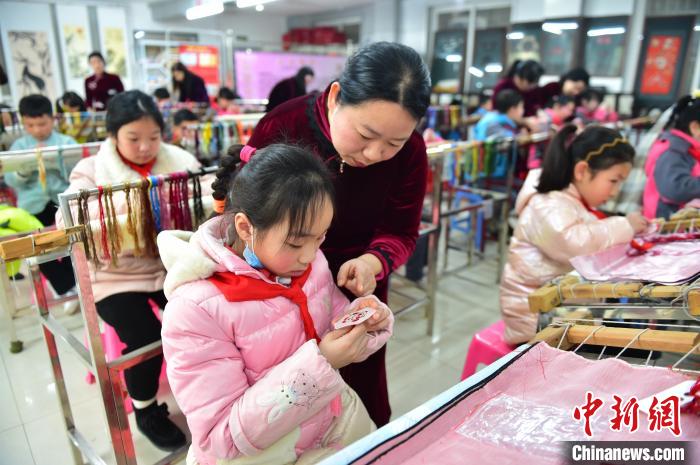 江西省級非遺豫章繡傳承人手把手指導(dǎo)小學(xué)生繡制2022年北京冬奧會吉祥物“冰墩墩”形象?！∮髟屏?攝
