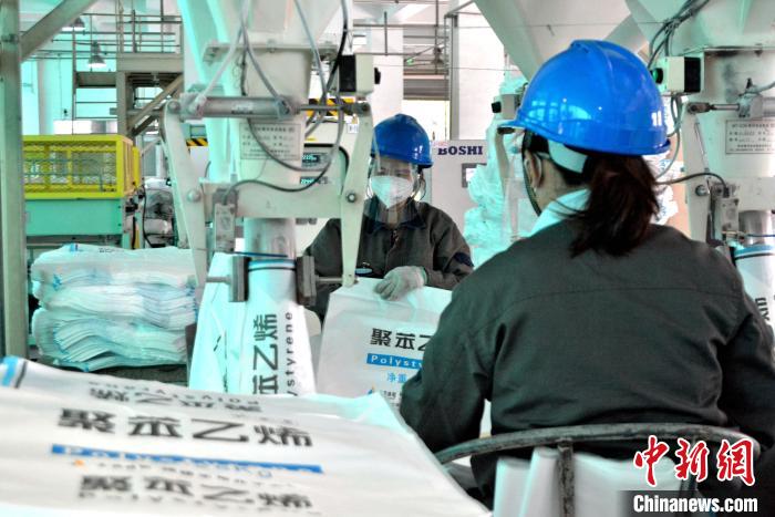 工人在生產(chǎn)線上包裝聚苯乙烯產(chǎn)品?！×趾霔v 攝