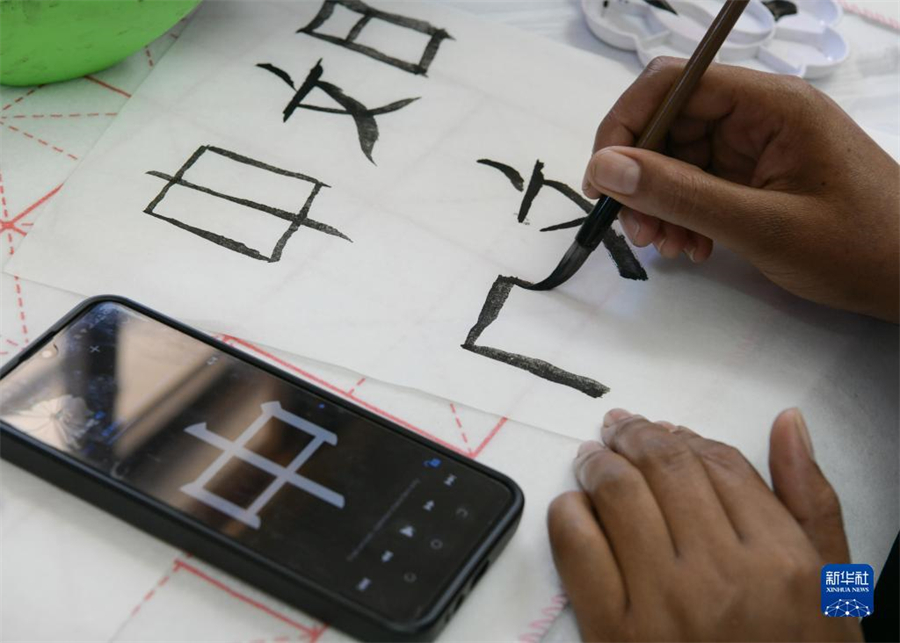 4月18日，肯尼亞學(xué)生在內(nèi)羅畢大學(xué)孔子學(xué)院舉辦的活動(dòng)上寫毛筆字?？夏醽唭?nèi)羅畢大學(xué)孔子學(xué)院18日舉辦“中文，增進(jìn)文明對(duì)話”主題活動(dòng)，慶祝即將到來(lái)的第14個(gè)聯(lián)合國(guó)中文日?？夏醽唽W(xué)生參與互動(dòng)，進(jìn)行書法、剪紙、唱中文歌等活動(dòng)。新華社記者 韓旭 攝