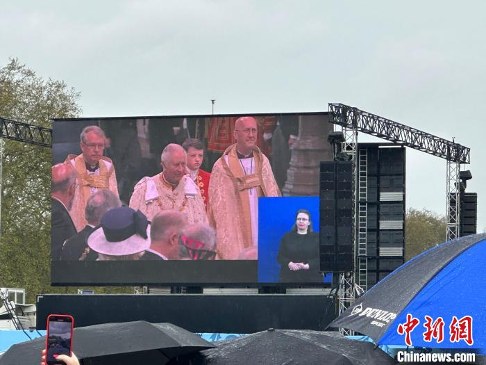 當(dāng)?shù)貢r間5月6日，英國國王查爾斯三世的加冕儀式舉行。民眾雨中觀看儀式。　歐陽開宇 攝