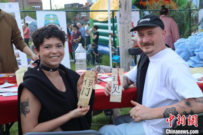 當?shù)孛癖娫跐h字體驗工作坊展示自己手寫的中文名書簽。　魯汶孔子學院供圖