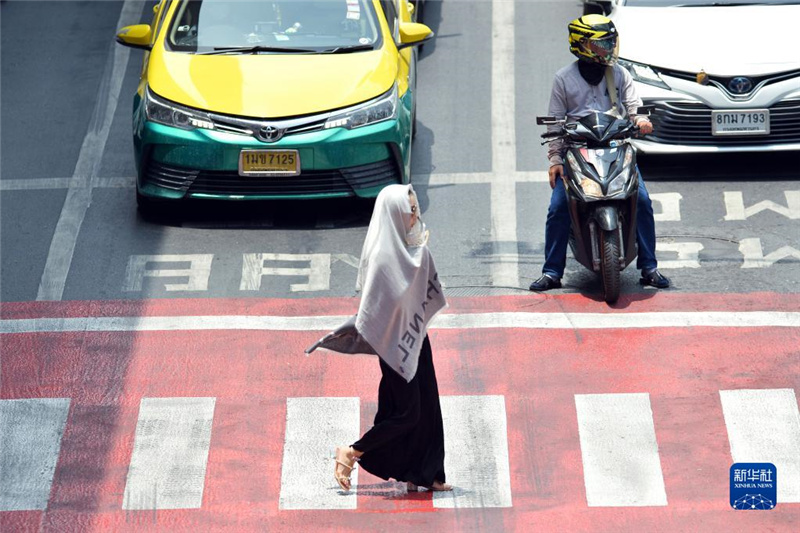 5月17日，行人在泰國(guó)曼谷街頭用圍巾遮陽(yáng)。新華社發(fā)（拉亨攝）