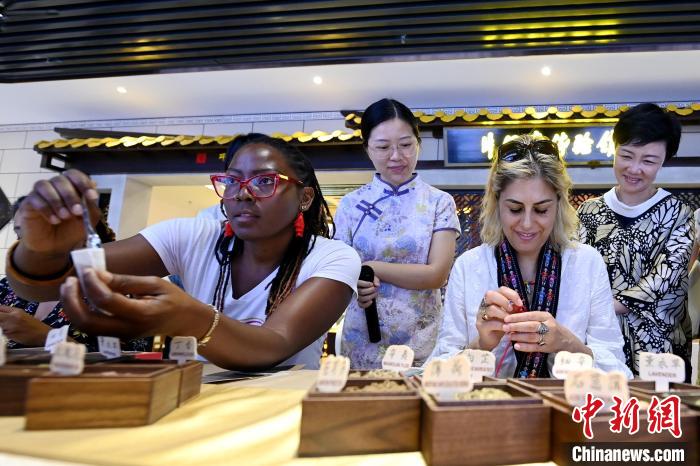 代表團成員在片仔癀博物館內(nèi)制作中藥配方香囊?！埥鸫?攝