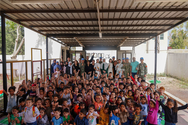 當(dāng)?shù)貢r間5月30日，黎巴嫩南部庫雷拉公立小學(xué)，“六一”國際兒童節(jié)前夕，中國第21批赴黎維和多功能工兵分隊官兵看望慰問學(xué)校師生，并開展文化交流活動，圖為我維和官兵同師生合影。李竹林?jǐn)z