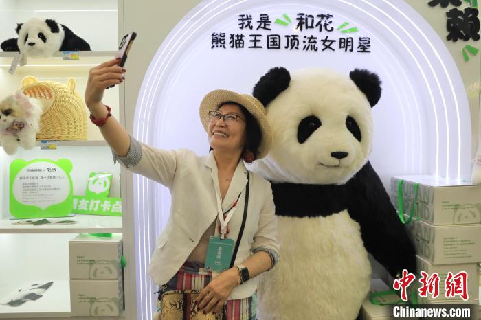 美國華視總裁楊蓮花與大熊貓文創(chuàng)產(chǎn)品合影?！⊥趵?攝