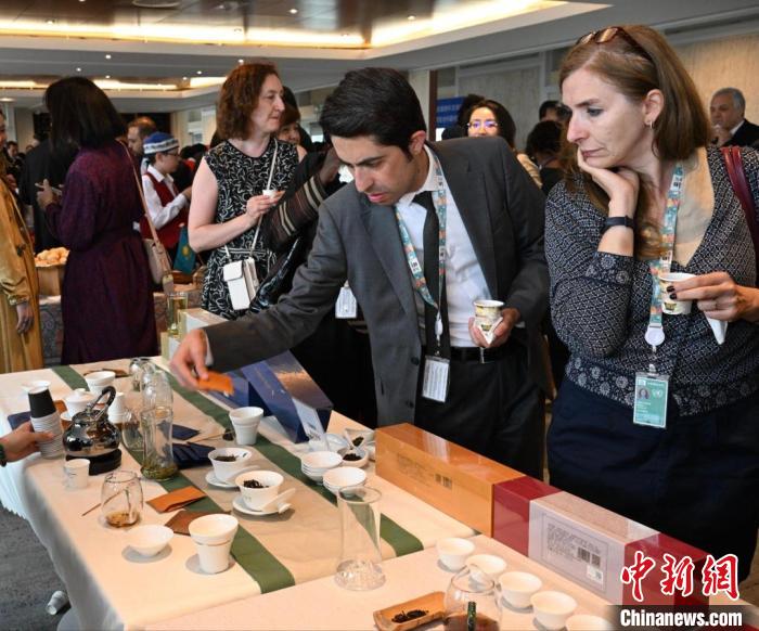 現(xiàn)場(chǎng)觀眾觀看中國(guó)展臺(tái)茶藝表演、了解茶文化?！【笜?攝