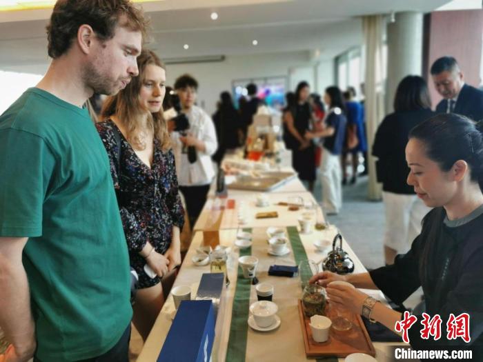現(xiàn)場(chǎng)觀眾觀看中國(guó)展臺(tái)茶藝表演、了解茶文化?！【笜?攝