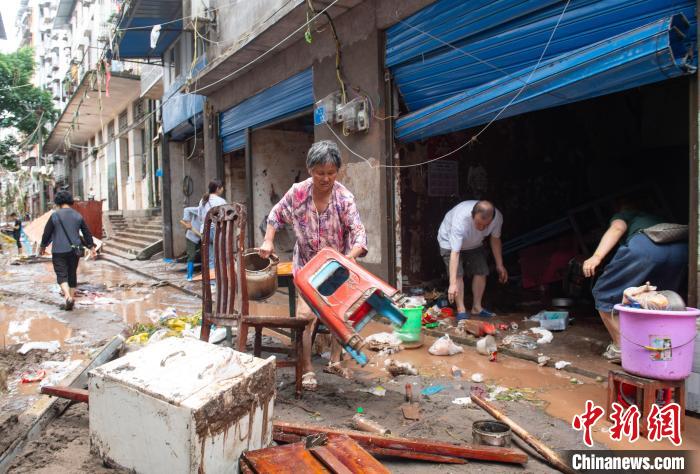 7月4日，萬州區(qū)五橋街道，洪水退去后，居民搶救生活物資?！∪矫宪?攝