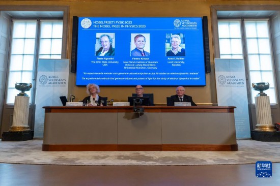 10月3日，在瑞典斯德哥爾摩舉行的2023年諾貝爾物理學(xué)獎公布現(xiàn)場，屏幕上顯示獎項(xiàng)得主皮埃爾·阿戈斯蒂尼（左）、費(fèi)倫茨·克勞斯（中）和安妮·呂利耶的照片。新華社發(fā)（魏學(xué)超攝）