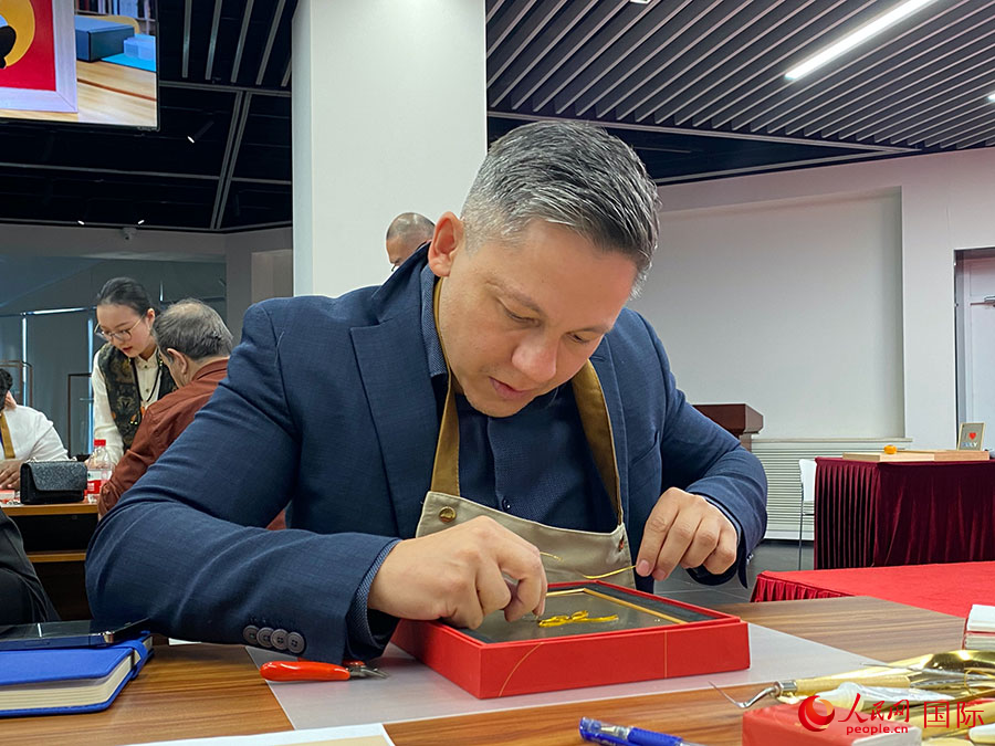 2023“一帶一路”媒體合作論壇聯(lián)合采訪團團員，親身體驗景泰藍工藝。人民網(wǎng)記者 于洋攝