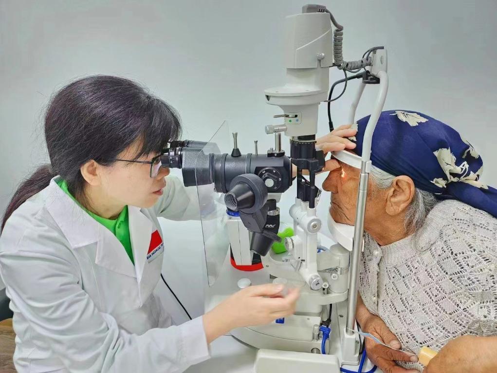 北京大學(xué)人民醫(yī)院眼科醫(yī)生鮑永珍正在為中亞白內(nèi)障患者進(jìn)行眼部檢查。（北京大學(xué)人民醫(yī)院供圖）