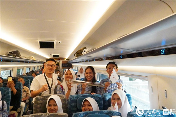 第一次乘坐雅萬高鐵動車組的學生們與動車組模型合影。人民網記者曹師韻攝