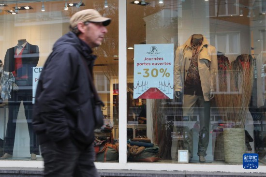   10月31日，一名男子從比利時布魯塞爾一家貼有打折信息的店鋪前走過。新華社記者 趙丁喆 攝