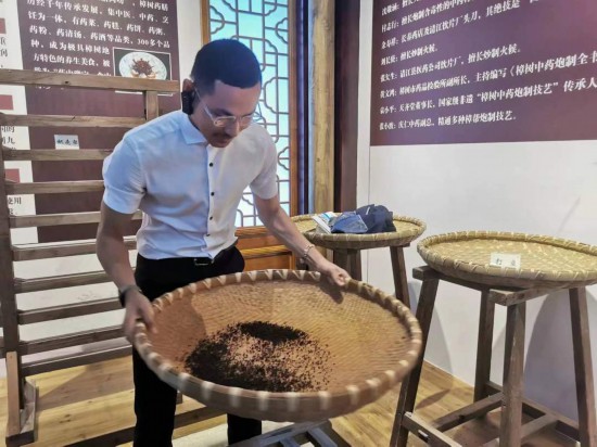 2023“一帶一路”媒體合作論壇聯(lián)合采訪團(tuán)團(tuán)員在非遺文化展示館體驗(yàn)中藥炮制技藝。（本報(bào)記者 黃超攝）