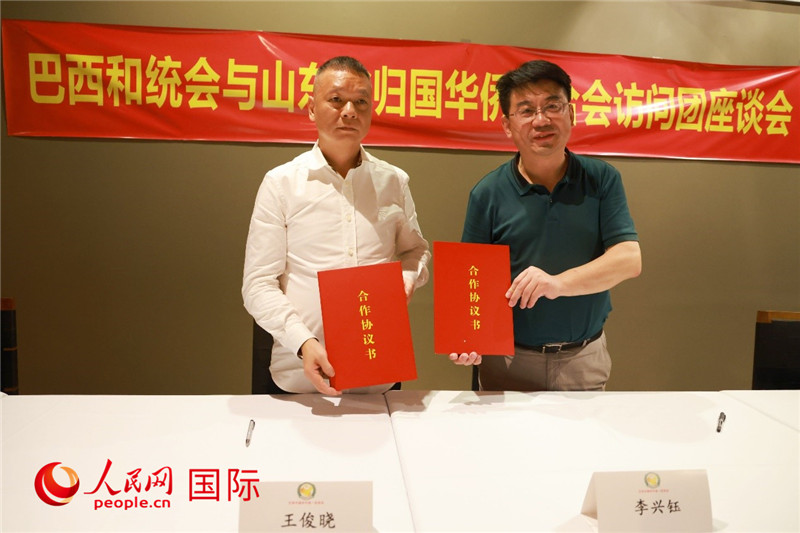 中國僑聯(lián)副主席、山東省僑聯(lián)主席李興鈺（右）與巴西和統(tǒng)會(huì)會(huì)長王俊曉簽署合作協(xié)議書。人民網(wǎng)記者 陳海琪攝