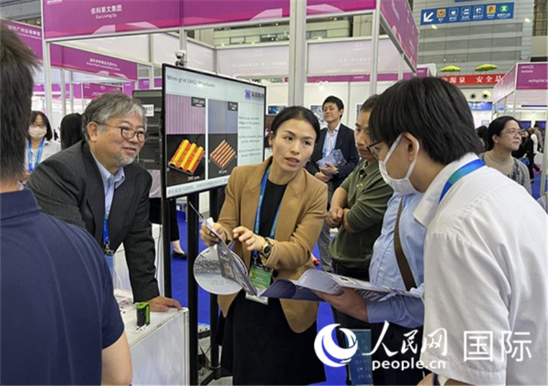 工作人員向參觀者介紹超級噴墨技術。(人民網(wǎng)記者 陳思攝)