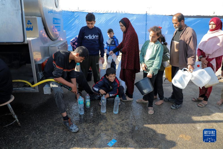 12月8日，在加沙地帶南部城市拉法一處臨時營地內(nèi)，人們排隊打水。新華社發(fā)（里澤克·阿卜杜勒賈瓦德 攝）