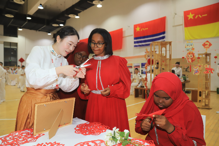 中國剪紙藝術吸引當?shù)厝耸繀⑴c體驗。陳錦俊攝