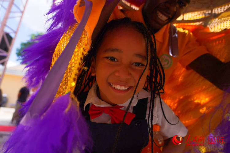 一名小朋友在與舞獅表演者互動。人民網記者 黃煒鑫攝