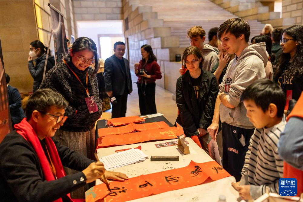 2月11日，書法家在美國費(fèi)城藝術(shù)博物館舉行的龍年迎新春活動上為參觀者書寫對聯(lián)。新華社發(fā)（周煥新攝）