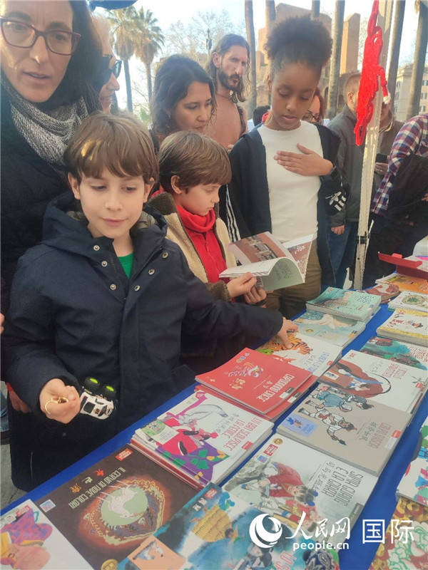 印刷精美的中國傳統(tǒng)文化叢書吸引了小游客的注意。人民網記者鄭彬攝