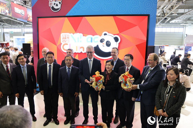 參加中國館開幕式的嘉賓們?cè)凇澳愫?中國” 展臺(tái)前合影留念。