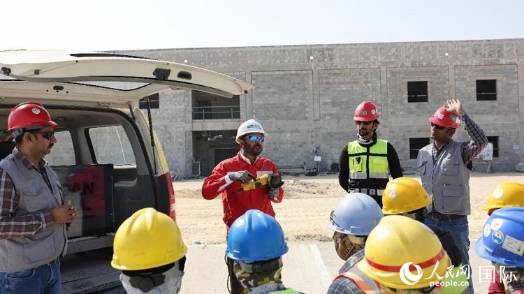 穆薩瓦爾(圖中紅衣人）現(xiàn)場(chǎng)演示工具操作規(guī)范。人民網(wǎng)記者 管克江攝