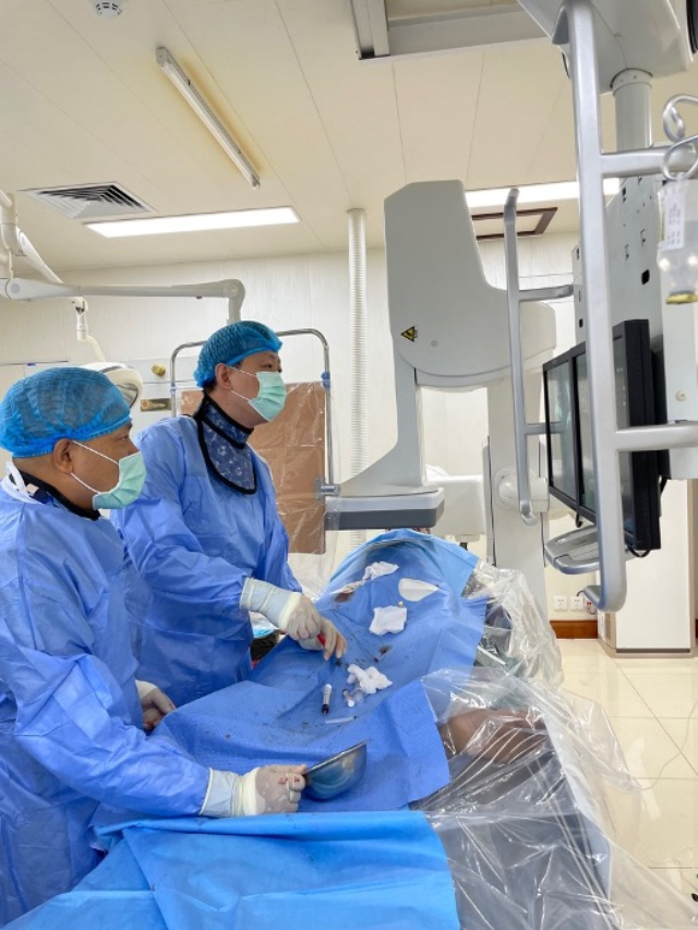 李凱教授（右）和劉海濤教授（左）為患者行TACE手術(shù)。中國(guó)駐老撾大使館供圖