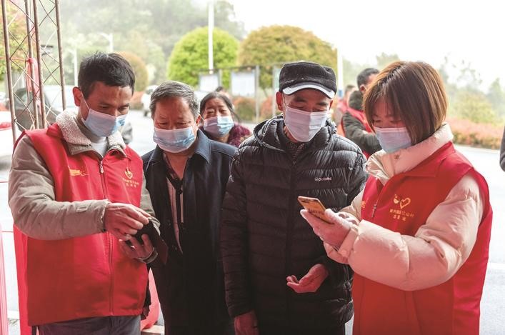 長沙縣黨員志愿者正在幫助參與核酸檢測的群眾掃描“場所碼”。劉思源 攝