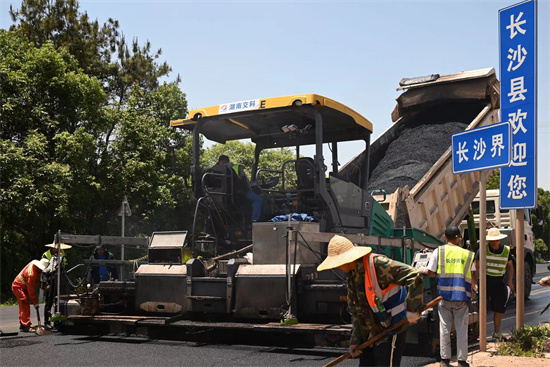 工人正在進(jìn)行“極薄磨耗層”路面的鋪筑。受訪單位供圖