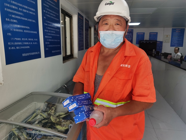 1環(huán)衛(wèi)工倪建宏小憩后，為還同事帶去冷飲。人民網(wǎng)記者王繼亮攝