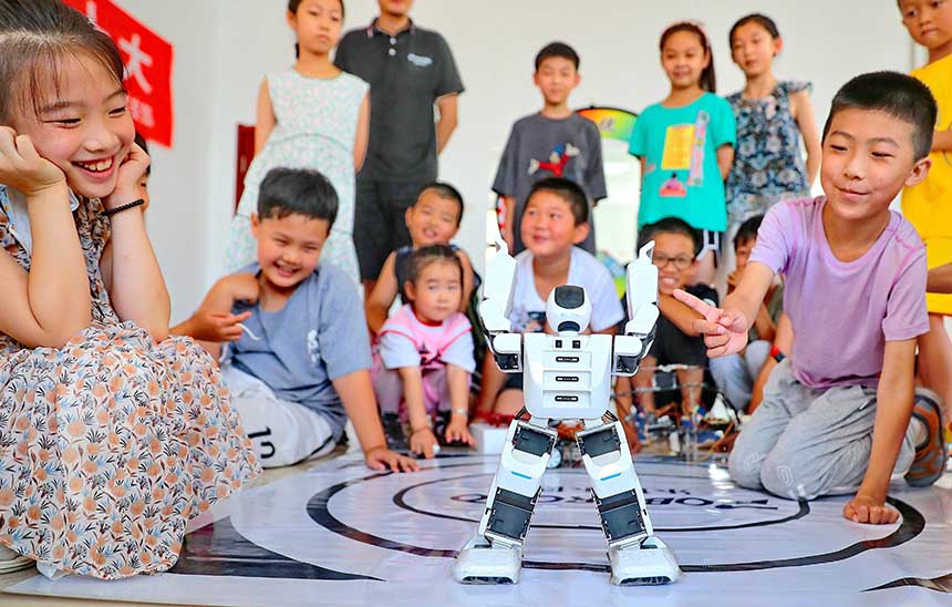 2022年7月19日，河北省秦皇島市海港區(qū)白塔嶺街道秦皇半島第二社區(qū)內(nèi)，小朋友正在觀看“機(jī)器人跳舞”。 曹建雄攝