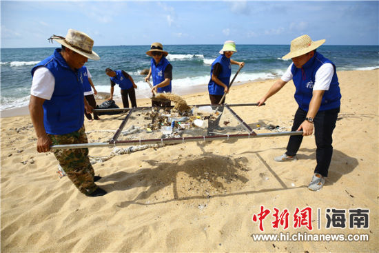 環(huán)保志愿者用篩網(wǎng)“淘”出海灘上的垃圾。