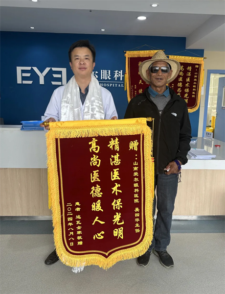 達(dá)瓦老人向吳四華（左）贈(zèng)送錦旗。受訪者供圖