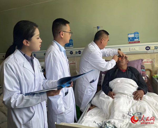 董光明（左三）帶領(lǐng)醫(yī)生對(duì)患者進(jìn)行術(shù)前檢查。人民網(wǎng)記者 杜燕飛攝