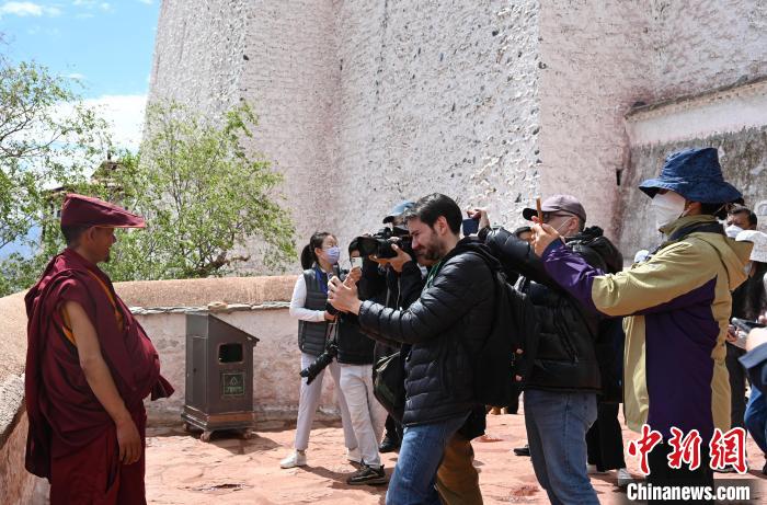 圖為中外媒體拍攝朝拜布達拉宮的僧人?！≮w朗 攝