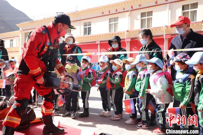 圖為消防指戰(zhàn)員為學(xué)生講解、演示先進救援裝備。　趙琳 攝