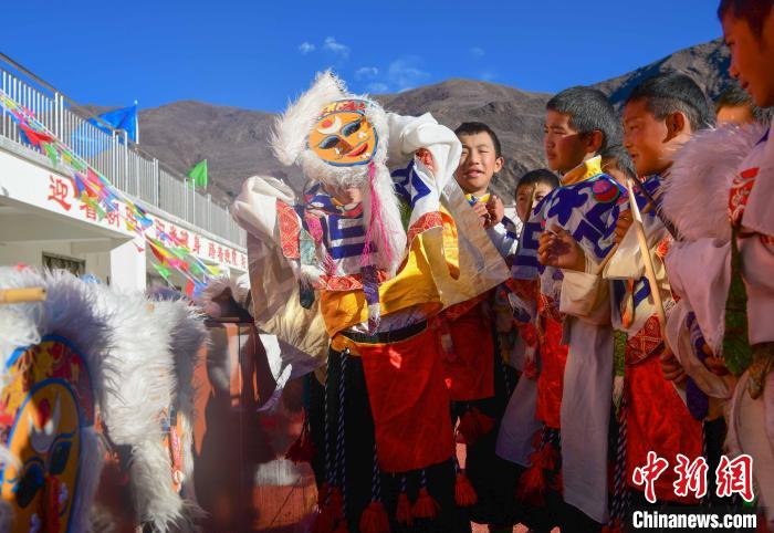圖為加查縣安繞鎮(zhèn)小學(xué)學(xué)生在試穿藏戲面具?！∝暩聛?lái)松 攝