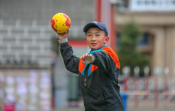 在高原上教孩子們打手球，“慢慢兒來，甭著急！”