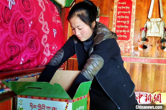 圖為通麥村村民巴桑拉姆把精心挑選的蘋(píng)果裝箱?！∝暽＠?攝