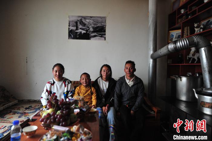 圖為8月12日，2018年7月從距那曲市色尼區(qū)城區(qū)那曲鎮(zhèn)90千米外的古露鎮(zhèn)當桑村搬遷至城區(qū)的旦增(右一)與家人在80多平方米的新家合影(資料圖)?！垈?攝