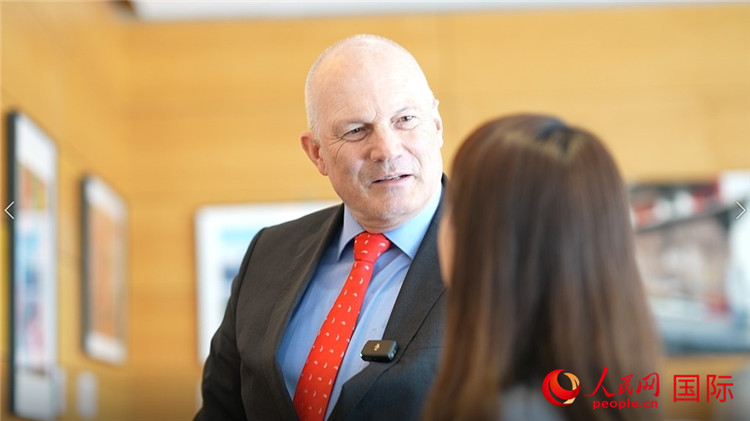 瑞士駐華大使白瑞誼介紹使館內(nèi)陳列的照片。人民網(wǎng) 彭昱凱攝