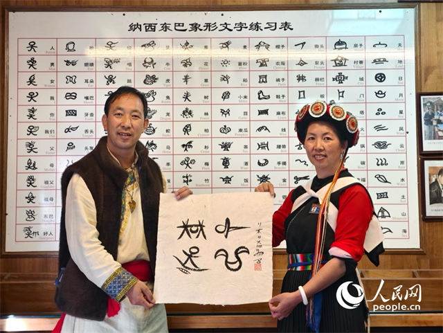 人民網(wǎng)“行進中國”云南調(diào)研采訪團走進麗江，和閏元現(xiàn)場用東巴文寫下“行進中國”。人民網(wǎng)記者 符皓攝