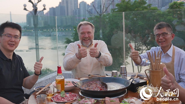 康寧顯示科技事業(yè)部全球拓建項目總監(jiān)軻寶華（中）和同事在重慶南濱路吃火鍋。人民網記者 蘇纓翔攝