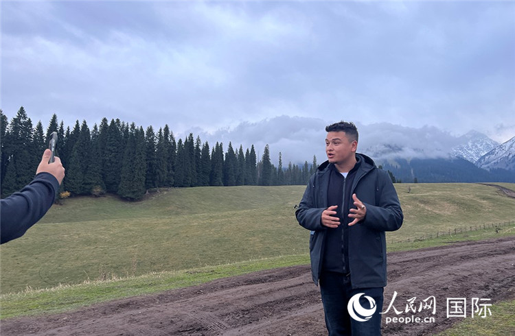 在庫(kù)爾德寧，吾買爾江被雪山美景震撼，即興錄制了短視頻作品。人民網(wǎng)記者曾書柔攝