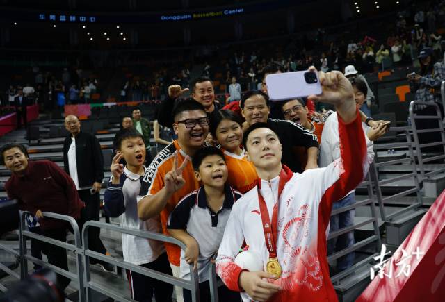 11月12日，十五運(yùn)會(huì)男籃成年組決賽，廣東隊(duì)獲得冠軍后，胡明軒與球迷們合影留念。張由瓊 攝