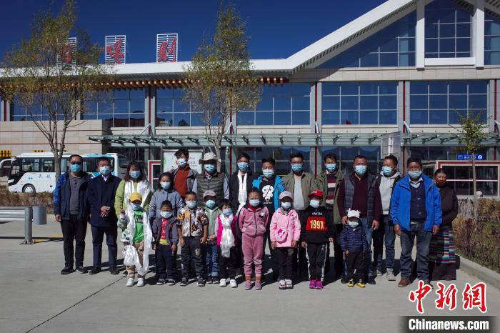 10位接受先心病治療的孩子及家長、工作人員等在日喀則和平機場合影?！〗w波 攝