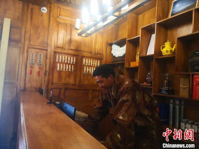 圖為桑杰才讓用電腦處理財務(wù)?！∈缝o靜 攝