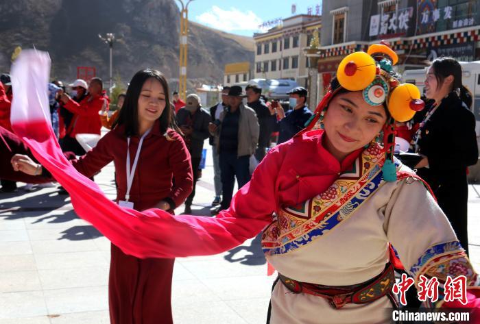 圖為中外記者向當(dāng)?shù)孛癖妼W(xué)習(xí)民族歌舞文化?！?zhí)砀?攝