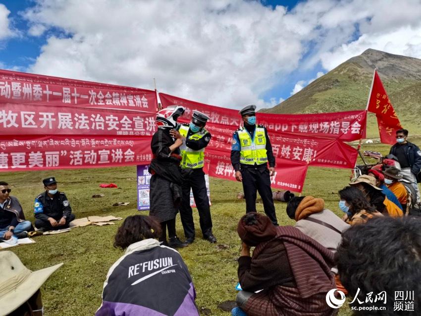 給牧民講如何佩戴安全頭盔。巴登攝